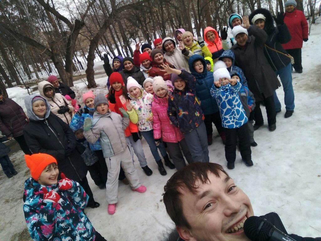 Ведущий с детьми и родителями на празднике на улице